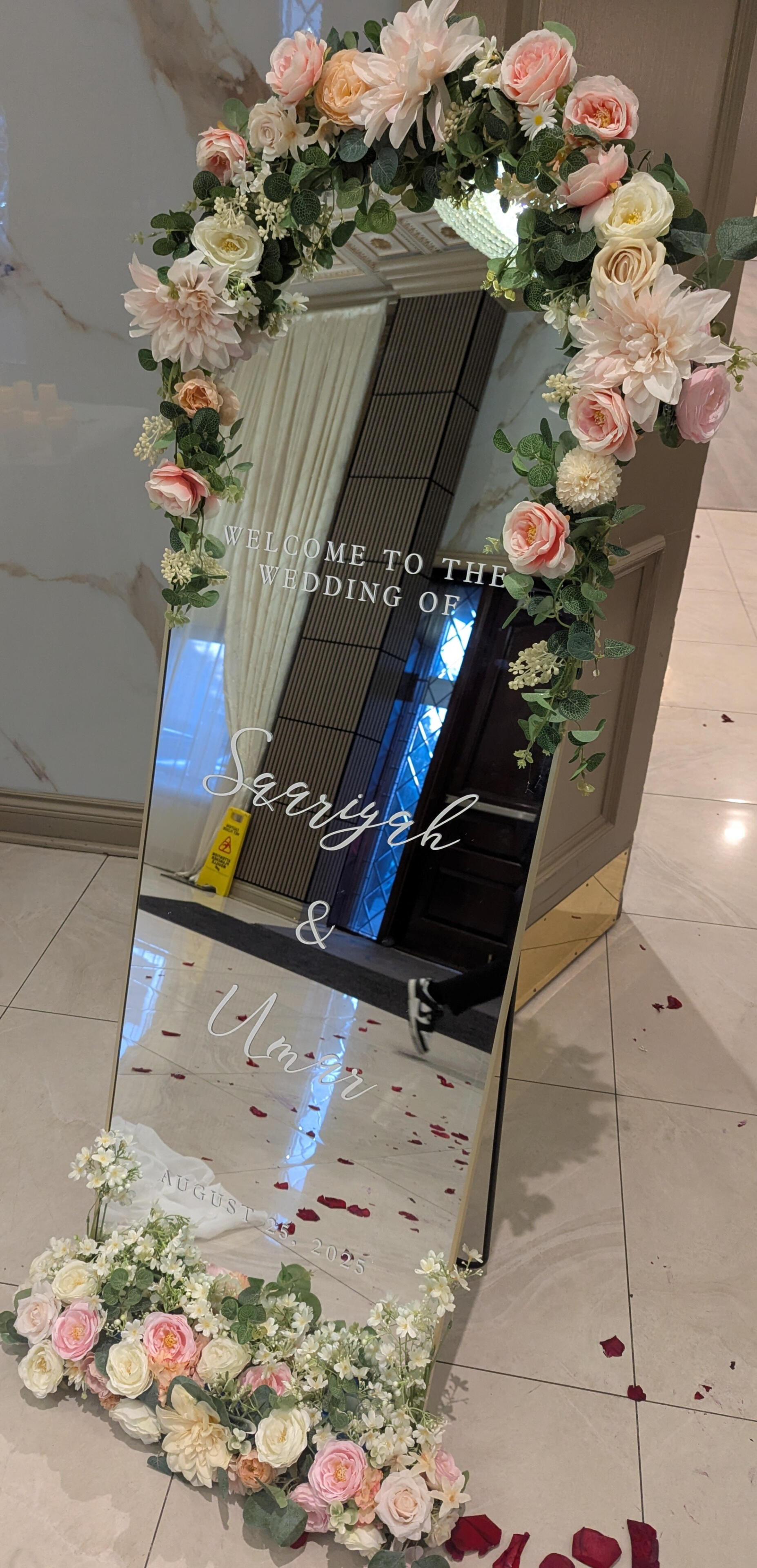 Welcome wedding mirror near entrance door in Mississauga Welcome wedding mirror for a reception at a venue in Mississauga. Mirror includes the date, couple's name and a welcome message.